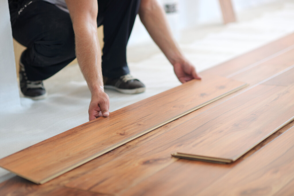 man laying down a hardwood floor